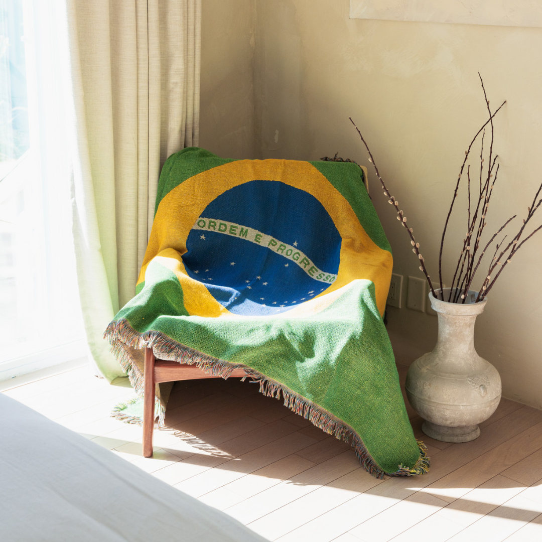 Brazil flag woven throw blanket draped over an armchair in a sunlit living room
