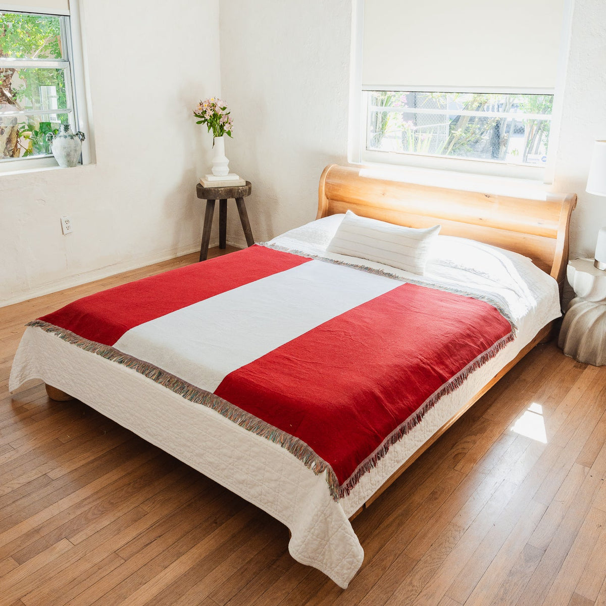 Peru flag woven throw blanket spread across a bed in a bright bedroom