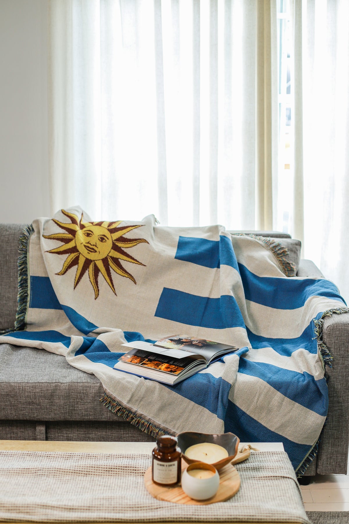 Uruguay flag woven throw blanket draped over a sofa in a living room