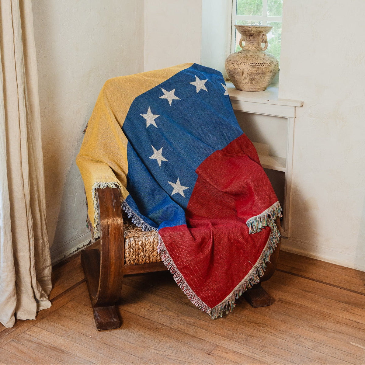 Venezuela flag woven throw blanket draped over an armchair in a sunlit living room